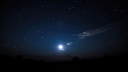 Obraz premium starry nighttime sky showcasing a luminous full moon over horizon
