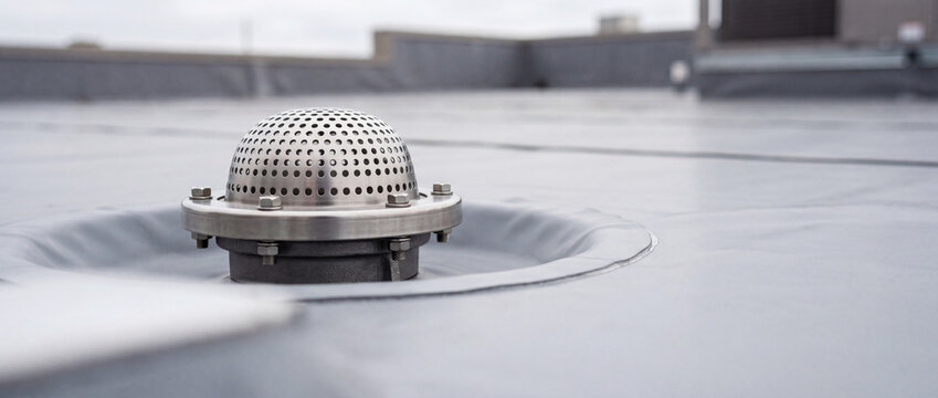 Commercial rooftop drain with perforated dome strainer on flat waterproof membrane roof