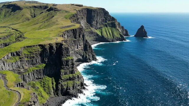 Breathtaking aerial view of rugged cliffs and ocean waves along a scenic coastline on a sunny day