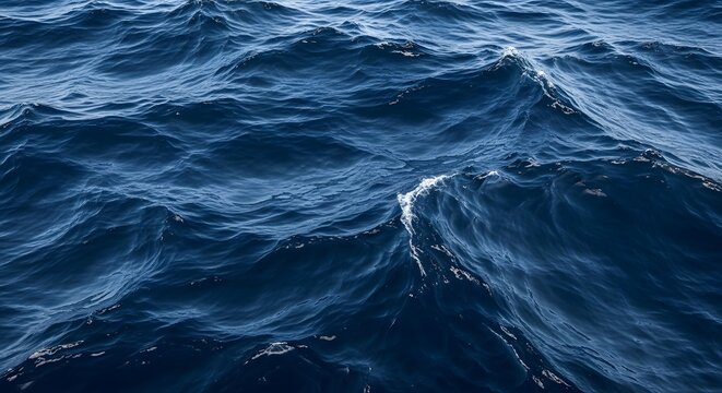 Deep blue ocean water texture with rough stormy waves, sea ripples, and dark marine background