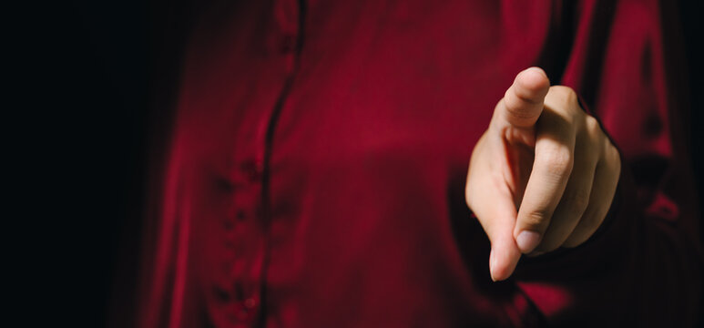 Pointing finger hand gesture red shirt close up human hand selective focus dark background adult casual clothing communication expression body language finger person adult hand human body part one