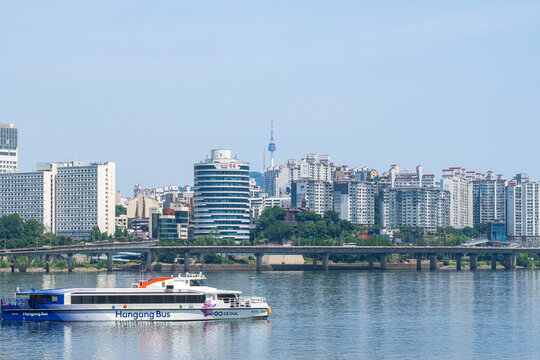 Seoul, South Korea - May. 24, 2026 : The Han River bus (river bus) cruising on the Han River with Namsan Seoul Tower and cityscape in the background on a clear spring afternoon