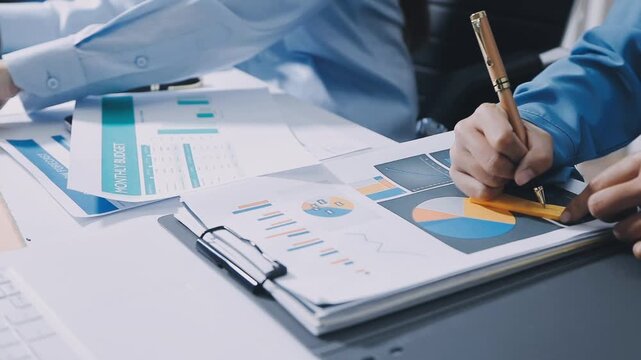 Young business people company employees having discussion about financial data analyzing company accounting on meeting. Woman accountant working on pc with charts and talking with colleague.