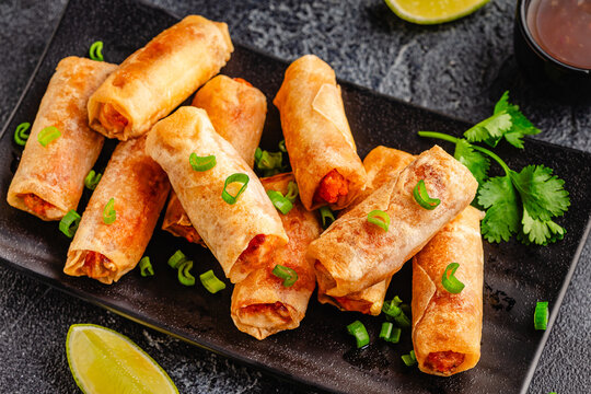 Fried spring rolls served with sauce and lime