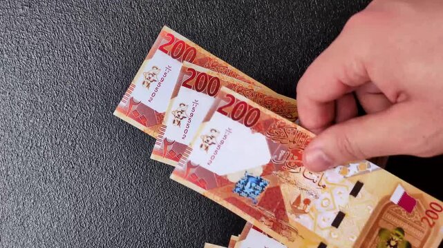 Qatar paper money, the Qatari riyal as a tool for financial transactions and trade. Qatari money as a business background for your design