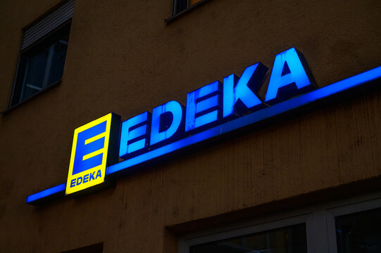 Augsburg, Germany - May 25, 2026: illuminated edeka store sign on building exterior at night