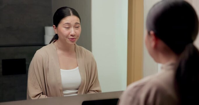 Affirmations, talking and woman by mirror in bathroom at house with self love, confidence or grooming. Happy, reflection and Asian female person with wellness routine, benefits or beauty motivation.