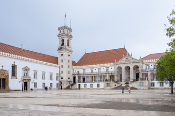 Fototapeta premium Coimbra, Portugal – Overcast view of the Courtyard of the Schools, featuring the baroque clock tower and Via Latina gallery at the University of Coimbra, Portugal's oldest university (1290). 