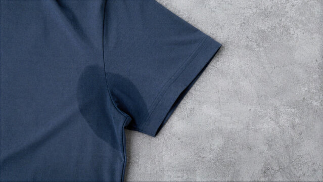 Visible sweat stain on the underarm of a dark blue cotton t-shirt