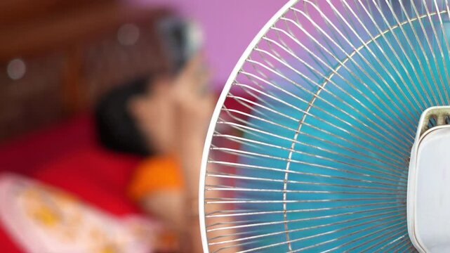 Indian Summer Heatwave Concept with Electric Fan Running in Bedroom. Close Up of Table Fan Blowing Air for Relief in Hot Indian Summer. Summer Heat in Room.