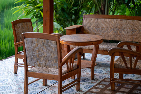 Javanese wooden furniture on patio looking out at green rice field