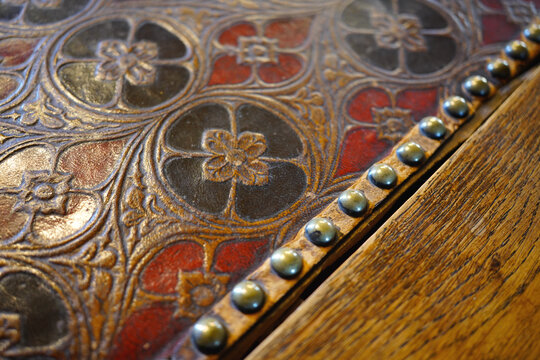 Embossed vintage leather surface with floral patterns and metal studs in Orleans France