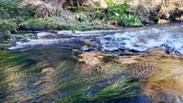 Base of duden waterfall with clear turquoise pool showing green algae riverbed and rushing rapids antalya.