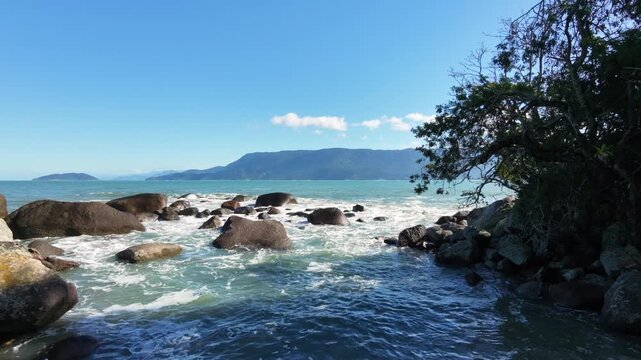 Tropical beach with waves hitting on the rocks at Brazil