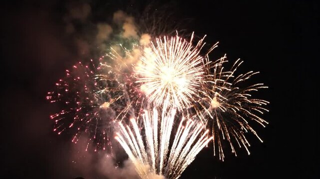 Vibrant fireworks display against night sky with colorful sparkles and smoke