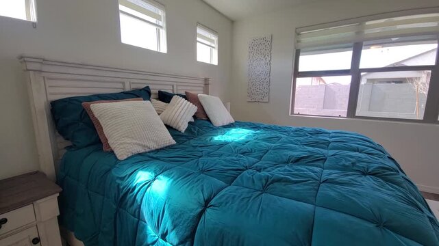 Bright modern bedroom with teal quilt