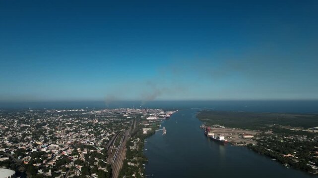 Cinematic 4K aerial dolly-in shot over the Panuco River mouth meeting the Gulf of Mexico, with Tampico, Ciudad Madero and Pueblo Viejo visible on both riverbanks