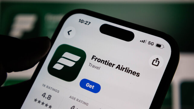 Closeup of a smartphone screen displaying the frontier airlines mobile app in the apple app store, showcasing the logo and download button