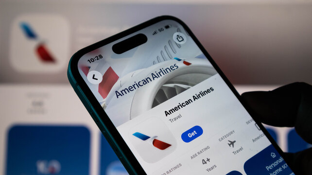 Closeup of a hand holding a smartphone displaying the american airlines mobile app page on the app store