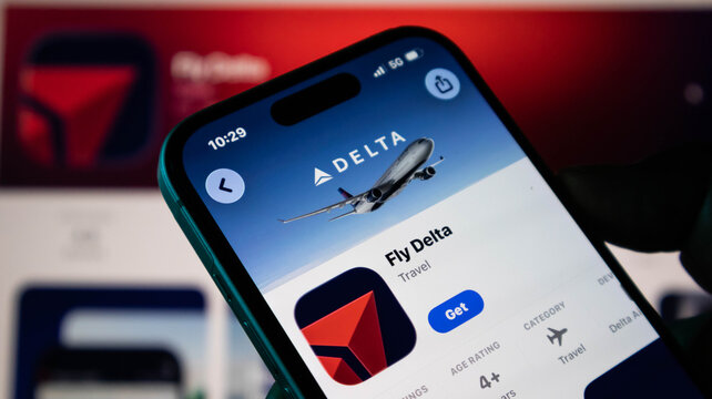 Closeup of a smartphone screen displaying the fly delta mobile application on the apple app store, showcasing the airlines branding and logo