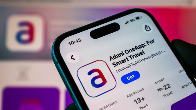Closeup of a smartphone screen displaying the adani one app on the apple app store, showcasing travel and flight tracking features