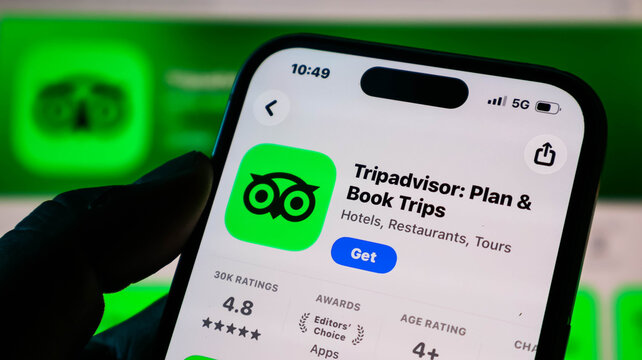 Closeup of a smartphone screen displaying the tripadvisor app page in the apple app store, showing the app icon, rating, and download button