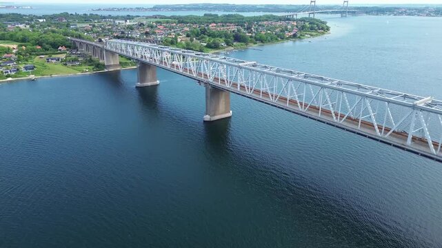 Historic Old Little Belt Bridge steel truss structure spanning the sea channel between Funen and Jutland. The footage showcases the architectural engineering of the landmark,