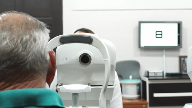 Senior man undergoing vision examination with auto refractometer
