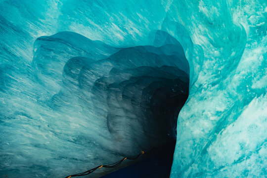 Turquoise glacier ice tunnel inside Mer de Glace cave in the French Alps