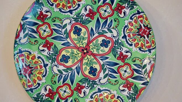Colorful decorative ceramic plate with intricate patterns and traditional design on a white surface