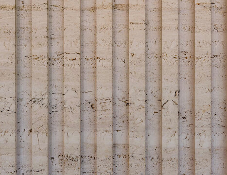 Unfilled travertine stone texture with vertical fluted grooves and natural limestone character suitable for elegant interior walls and architectural surface design