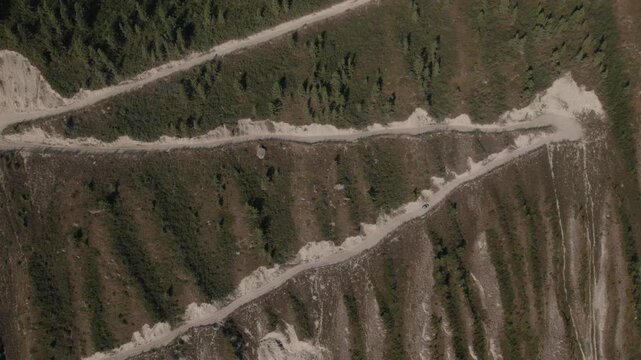 Drone footage of the winding zigzag dirt road on the steep mountainside at Katu-Yaryk Pass in the Altai Republic, Russia, summer travel landscape