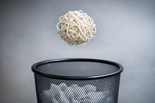 A black trash can filled with noodles