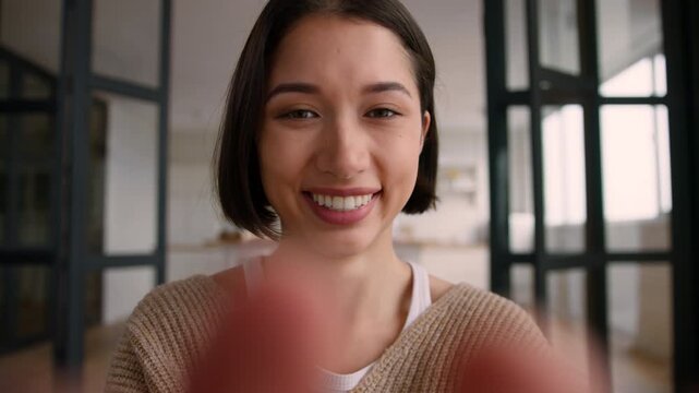 POV webcam happy Caucasian woman at home typing on mobile phone smiling chatting point of view addiction social media influencer online girl female laugh fingers message cellphone touch screen addict