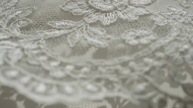 Delicate details of lace fabric showing floral designs and intricate patterns in bright light