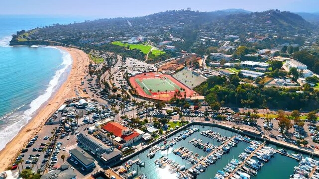 Lively scenery of Santa Barbara, California, USA from drone footage on sunny day. Flight over marina with numerous boats.