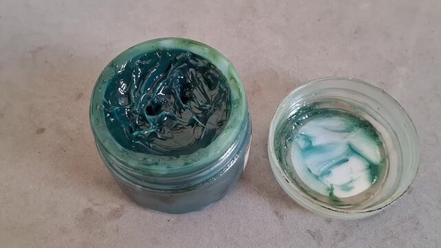 Open container of thick blue industrial grease for mechanical motion footage