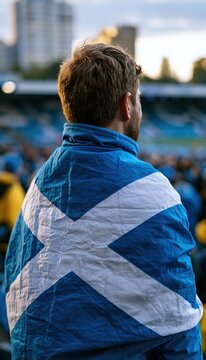 Scottish football fan wrapped in national flag at stadium