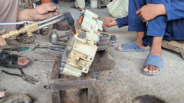 Skilled craftsman expertly repairs intricate machinery with a high-temperature torch, showcasing meticulous attention to detail and technical expertise in a workshop setting