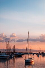 Obraz premium Single sailboat reflecting on harbor water during pink sunset