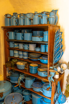 Vintage blue enamel kitchenware collection on wooden shelves