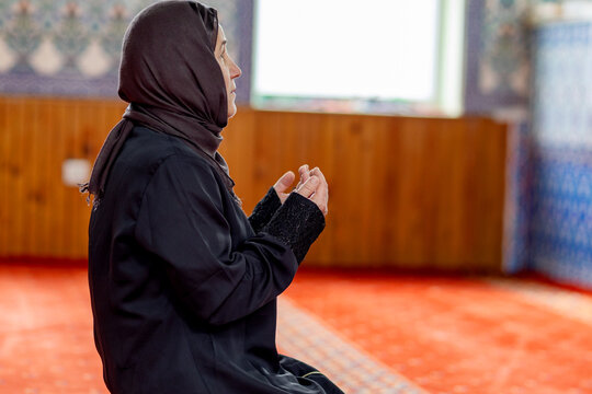 Muslim woman praying in mosque interior during worship