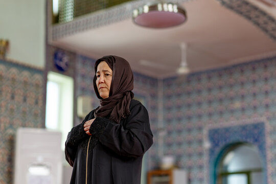 Muslim woman praying inside mosque with traditional hijab