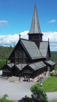 Wooden church in Oslo, Norway.  Aerial drone view of Holmenkollen chapel, a tourist destination registered in Norway's cultural heritage database. Vertical design in 9:16 ratio.