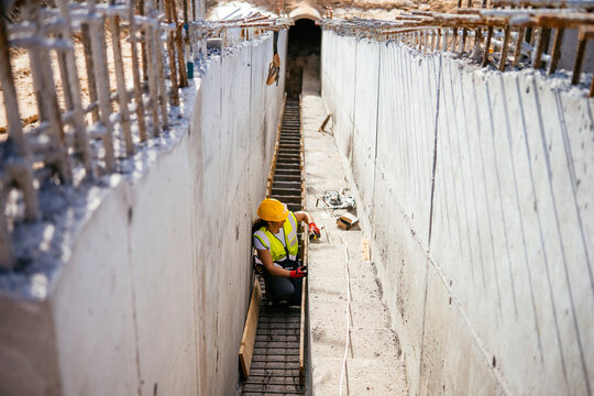 Female construction worker in helmet inspecting site safety