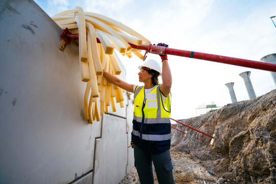 Construction Worker Handling Protective Foam Tubes