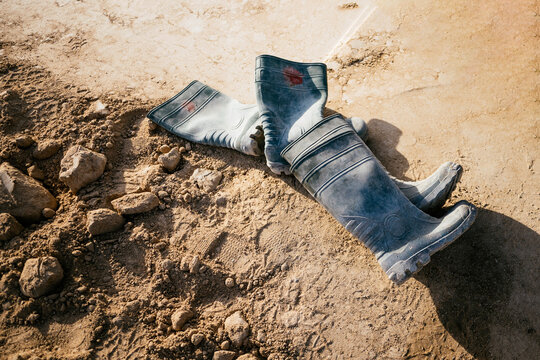 Abandoned work boots on dusty construction site ground
