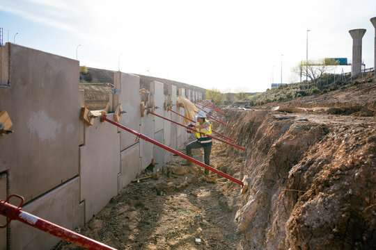Female construction worker inspecting concrete wall formwork