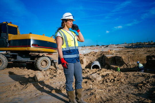 Female construction worker calling on smartphone at jobsite