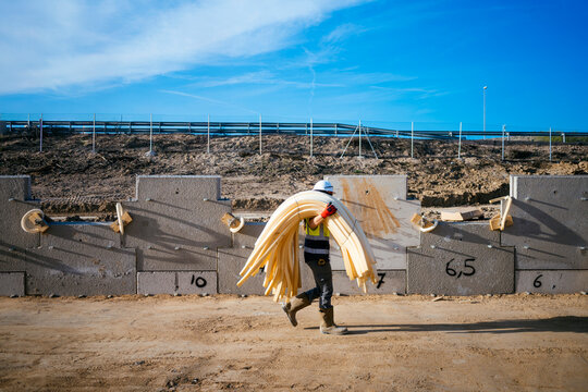 Female construction worker carrying bundled foam insulation